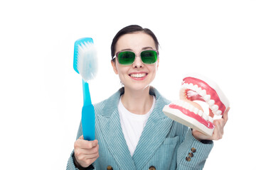 funny woman in green glasses holding big toothbrush and big jaw mockup, white background