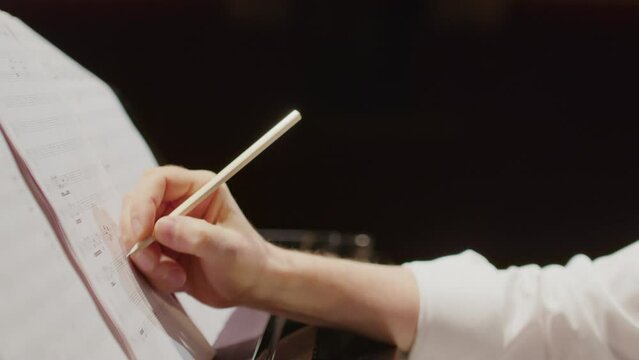 Close up view of talented composer creating sheet music and playing piano