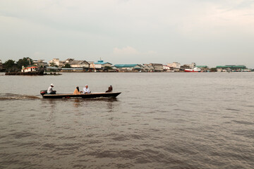 Activities of local residents around the Kapuas river: fishing, cycling, and crossing the river using canoes.
