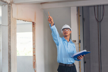 Construction engineer man hold blueprint wear blue shirt safety white hard hat at construction site industry labor worker. Architecture man engineer civil worker look at blueprint real estate concept