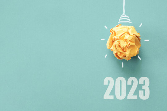 2023 Yellow paper light bulb on blue background, innovative business vision and resolution concept