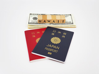 HAWAIIと書かれたブロックとパスポートと100ドル札