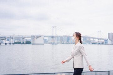 マスクをして都会を歩くビジネスウーマン