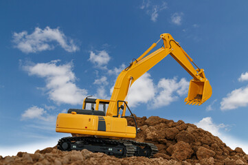 Excavator  are digging  soil in the construction site on sky  background,with white fluffy cloud