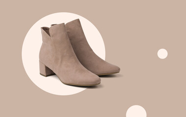Stylish beige women's suede boots on an abstract beige background.