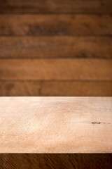 empty wooden table top and blurry wood plank wall, food or product photography background or backdrop, side view in shallow depth of field, copy space