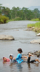 Three girls are happy to play water in the river