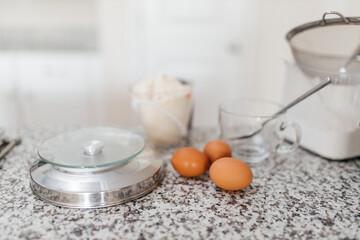 Baking ingredients are on the table. Eggs, flour, sugar are prepared for making macaroons. Kitchen background