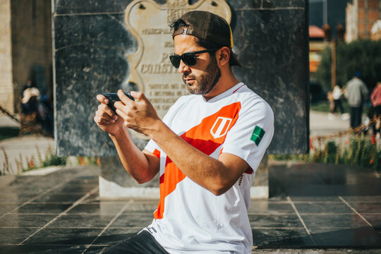 Hincha de futbol peruano sosteniendo su tel&eacute;fono. Concepto de personas y tecnolog&iacute;a.