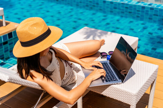Young woman freelancer traveler working online using laptop while traveling on summer vacation, Freelance and workation concept