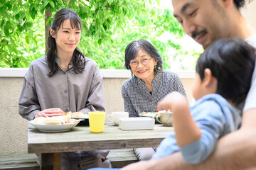 子どもをお世話する父を見守る祖母や母