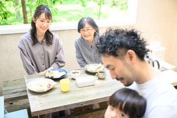 子どもをお世話する父を見守る祖母や母