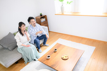 Couple relaxing in the living room Overhead view