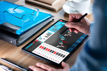 Businessman analyzing investment stock market and economic growth graph chart on tablet