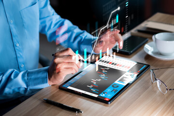 Businessman analyzing investment stock market and economic growth graph chart on tablet
