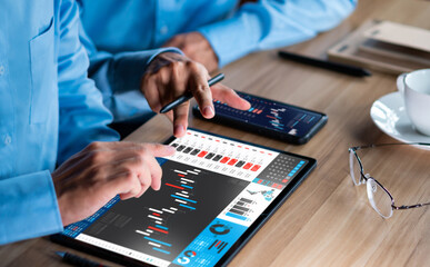 Businessman analyzing investment stock market and economic growth graph chart on tablet - obrazy, fototapety, plakaty