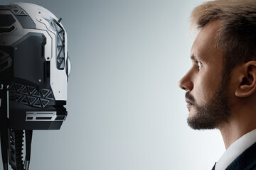 The face of a businessman and a robot opposite each other look into the eyes. Modern technologies,...
