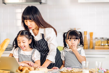 Portrait of enjoy happy love asian family mother and little toddler asian girl daughter child having fun cooking together with dough for homemade bake cookie and cake ingredient on table in kitchen