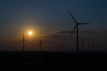 Sunset over a windmill park. An example of renewable energy, clean nature and a sustainable future. Earth Day