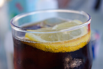 Close up of glass of cola with lemon