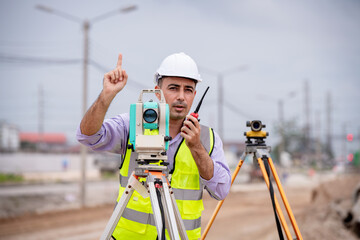 Surveyor engineer wearing safety uniform and helmet with equipment theodolite to measurement...