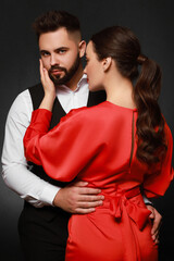 Handsome bearded man with sexy lady on dark background