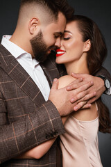 Handsome bearded man with sexy lady on grey background