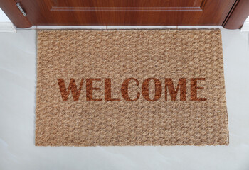 Door mat with word WELCOME near entrance, top view