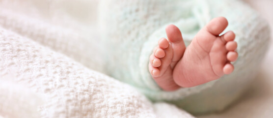 Newborn baby lying on plaid, closeup view with space for text