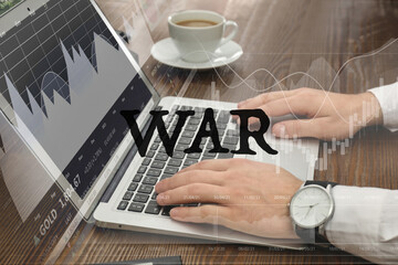 Fototapeta na wymiar Influence of war on stock exchange. Man using laptop at table and illustration of rating graph