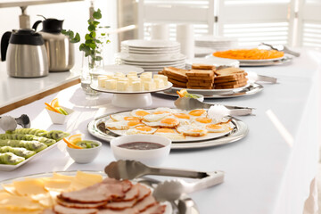 Different meals for breakfast on white table indoors. Buffet service