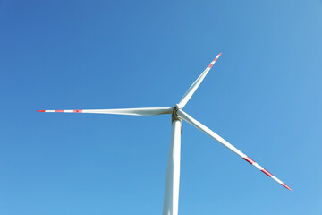 Modern wind turbine against blue sky, low angle view. Alternative energy source