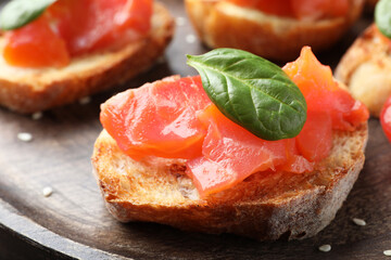 Delicious sandwich with salmon and spinach on wooden board, closeup