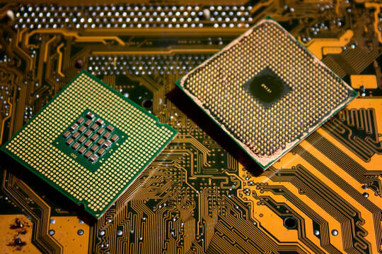 Isolated CPU or central processing unit on microcircuit background. Two CPU and two socket types. Socket 775 and Socket 754. Yellow motherboard. Technological background