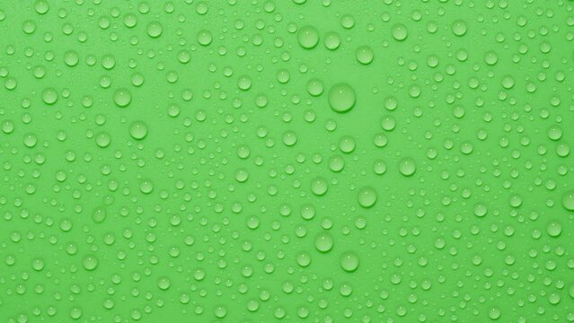 Close-up transparent water drops texture rotating on green chroma key background
