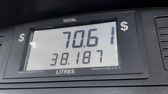 Gas price screen in dollars on fuel pump increasing based on litres, close up