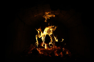 Background of the flame in the oven. Tongues of fire in a brick fireplace. Fire texture.