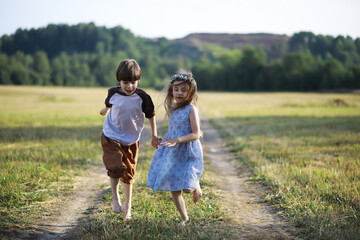 Fototapeta premium Children walk in the summer in nature. Child on a sunny spring morning in the park. Traveling with children.