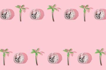 Summer creative pattern with  disco ball decoration and palm tree figurine on pastel pink background. 80s or 90s retro fashion aesthetic party concept. Minimal summer pop art idea with copy space.