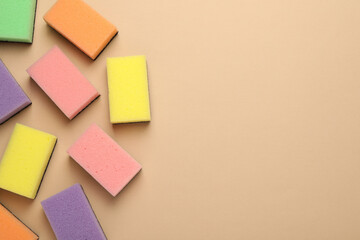New sponges on beige background, flat lay. Space for text