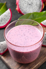 Delicious pitahaya smoothie and fresh fruits on black table, closeup