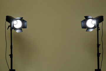 Modern spotlights against beige background, space for text