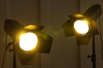 Bright yellow spotlights near wall indoors. Professional stage equipment