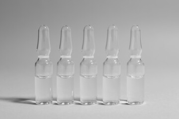 Pharmaceutical ampoules with medication on light grey background