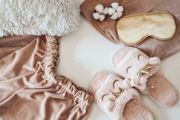 Flat lay composition with house slippers, sleeping mask and pajamas on light background