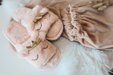 Home slippers and cozy pajamas on a fluffy white plaid