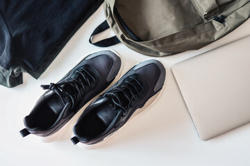 Set of men's things, flat lay top view. Sneakers, backpack, laptop on white background