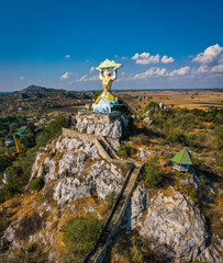 Aerial view of Wat Khao Samo Khon temple, with hanuman monkey god statue on top of mountain, in...