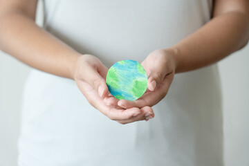 Woman hands holding paper colored earth element to empowered saving the world concept. Love and care to the earth.