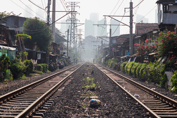 Fototapeta premium selective focus of double track jakarta electric railway with high office building background